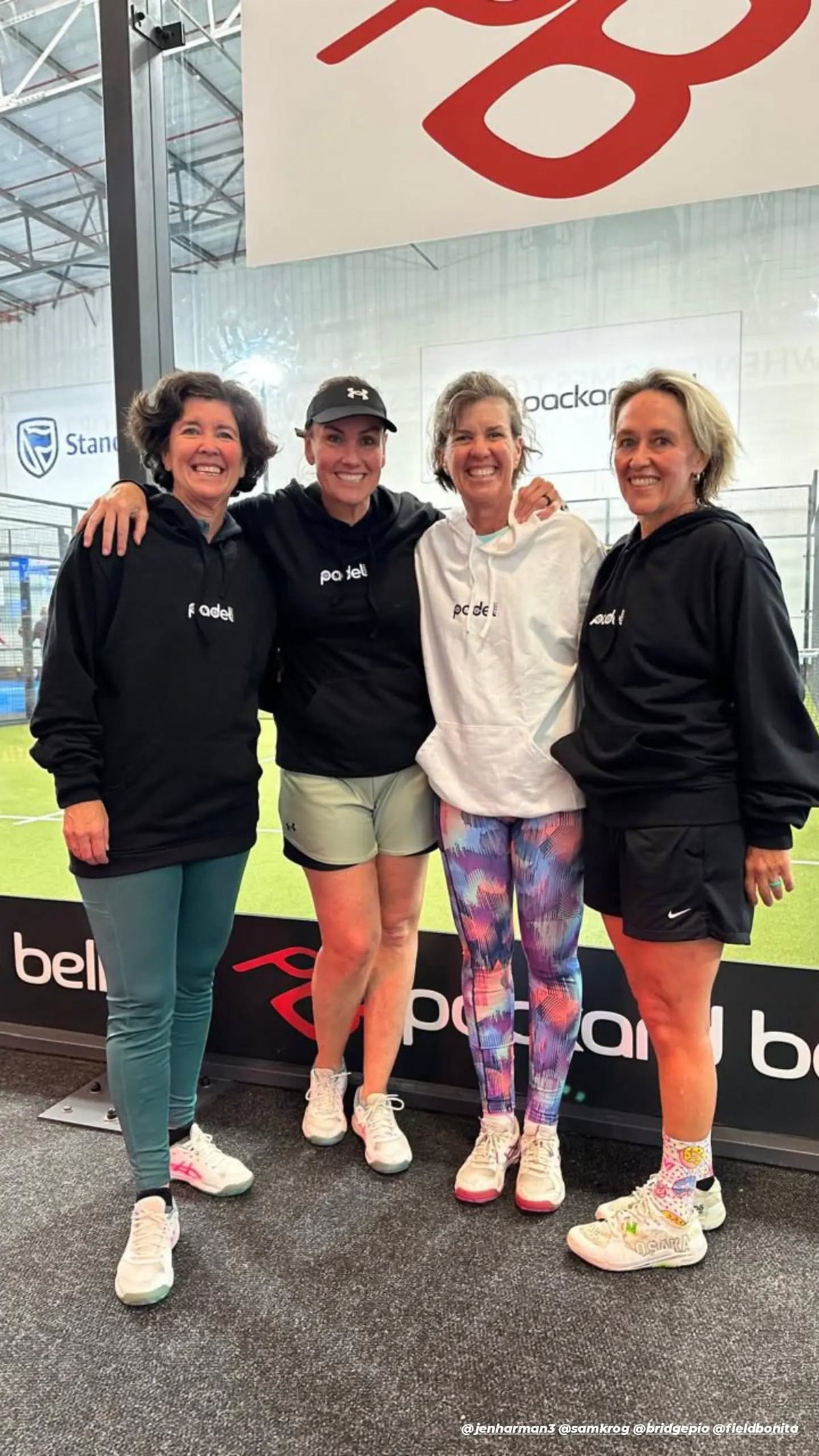 Four padel players smiling in Zazu hoodies
