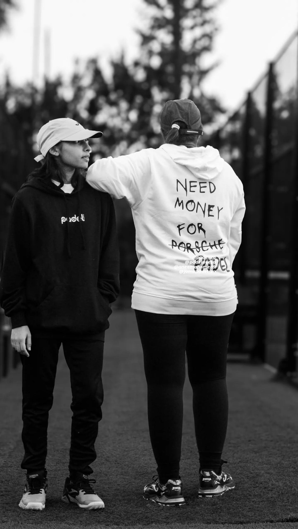 Two Zazu customers in black and white apparel at a padel event