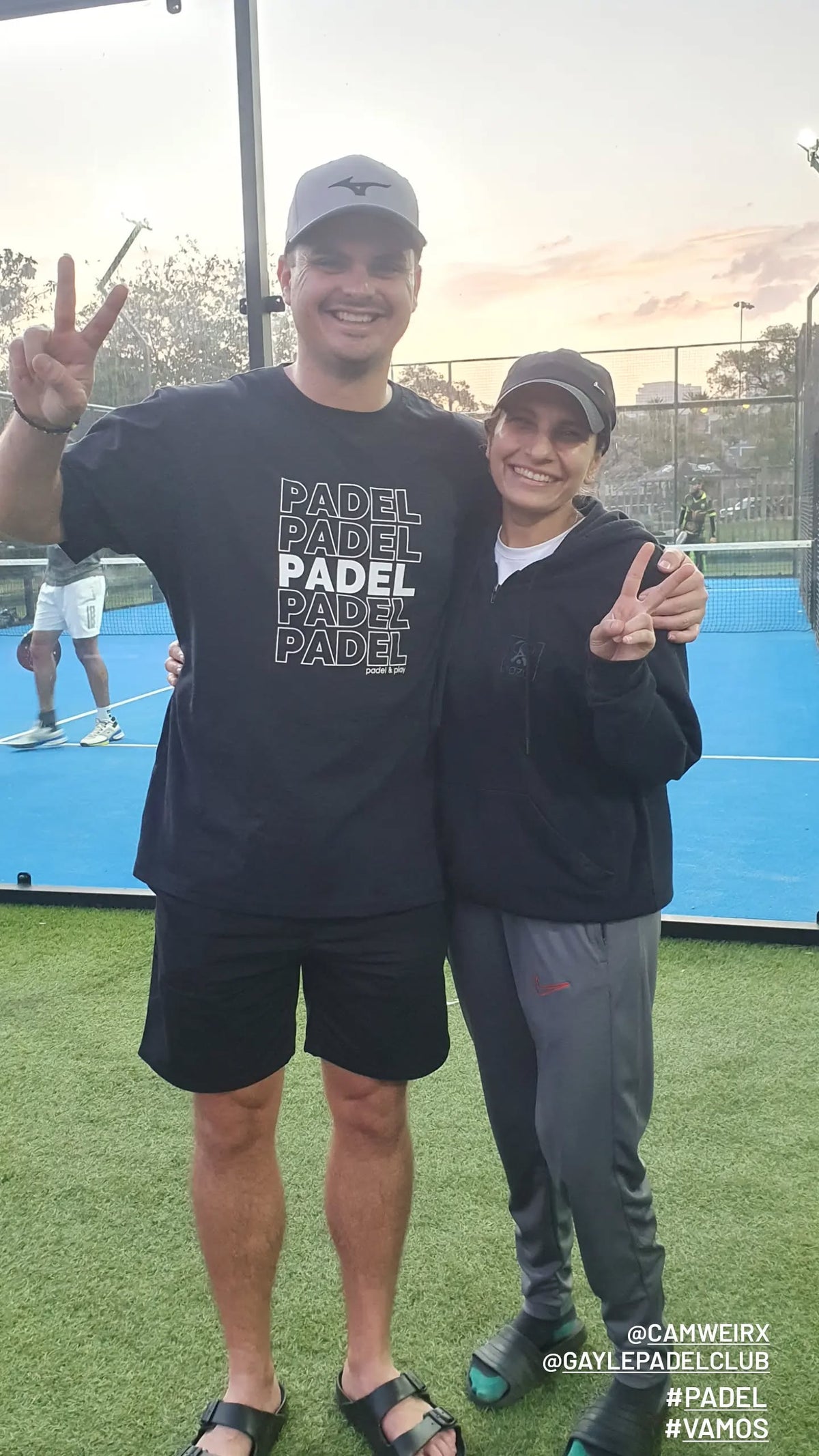 Two Zazu customers giving a thumbs up beside a padel court